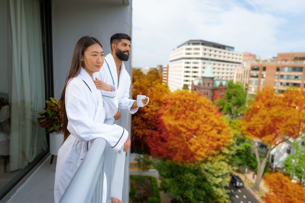 Couple at Hotel Madera's room balcony, in their robes, enjoying their morning coffee. 